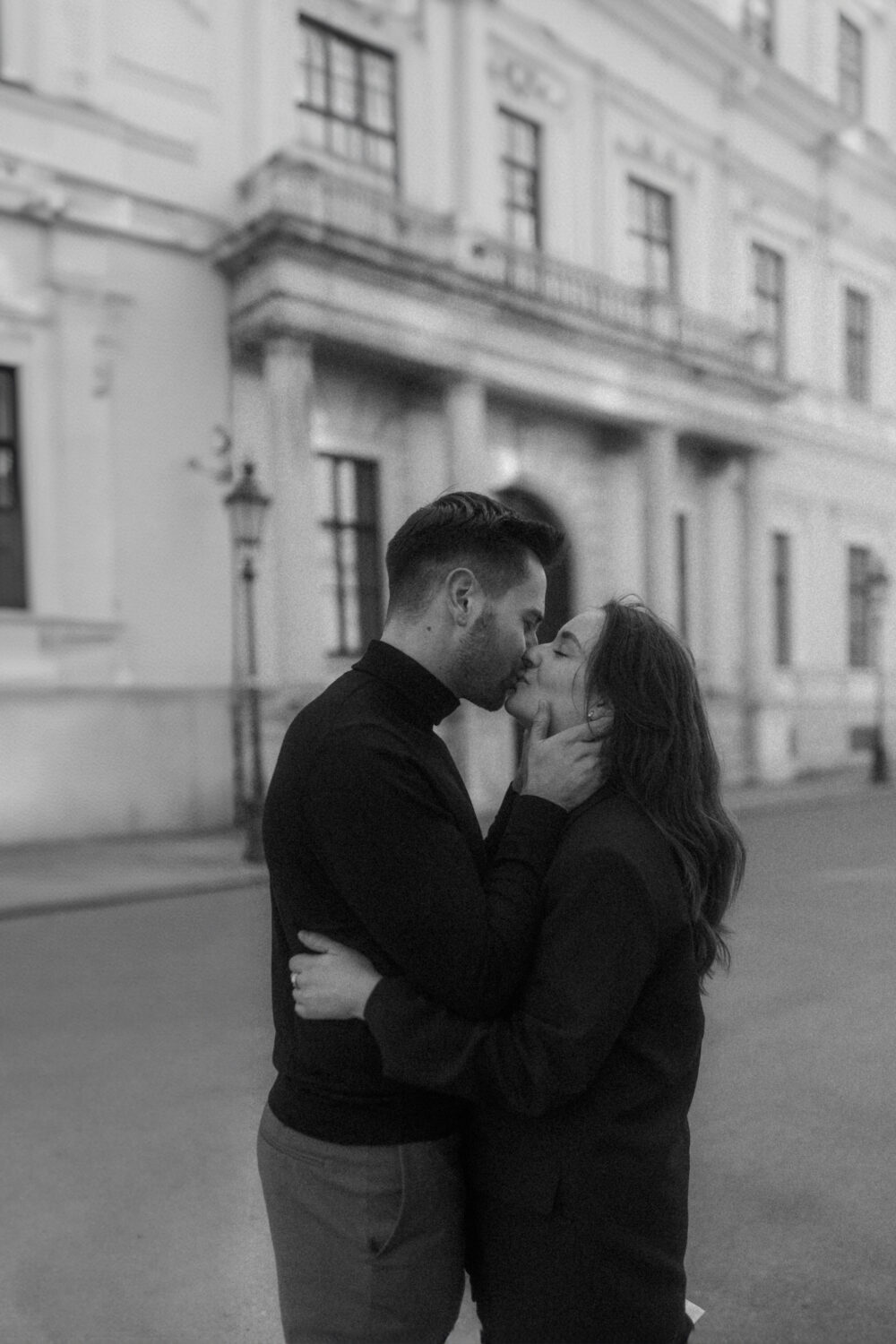 Couple kissing in front of an building in Munich.