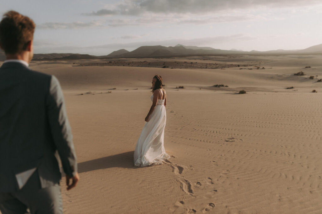 Bride walking through dunes during golden hour in Spain wedding