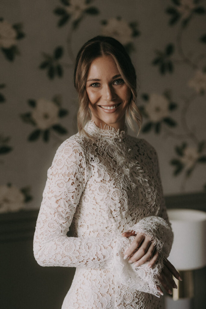 Bride in lace wedding dress smiling – elegant bridal portrait by wedding photographer Spain