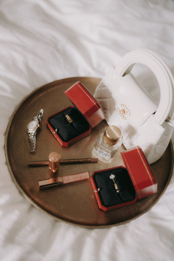 Wedding rings, perfume and accessories styled for flatlay – luxury detail by wedding photographer Spain