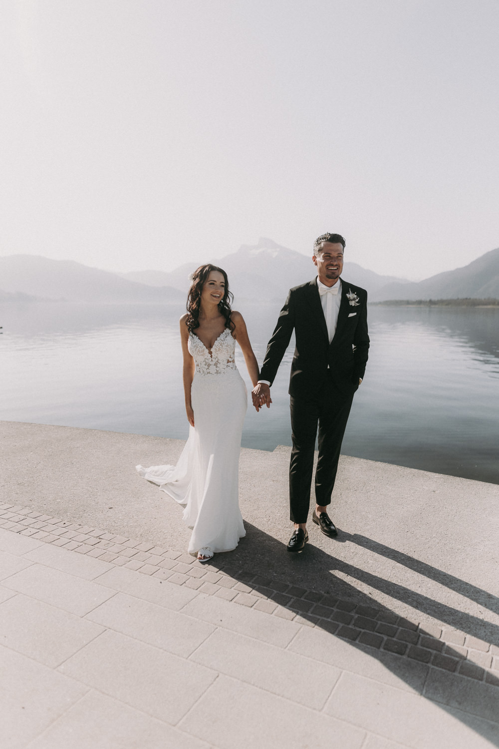 Hochzeitspaar beim Spaziergang am Gardasee, Braut hält ihren Blumenstrauß