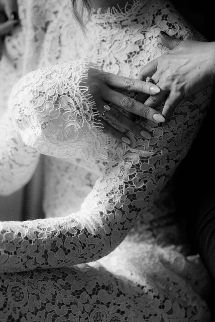Tender moment with lace sleeve and hand – emotional wedding detail by photographer in Spain