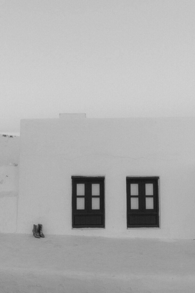 Wedding boots on white Spanish architecture with black windows