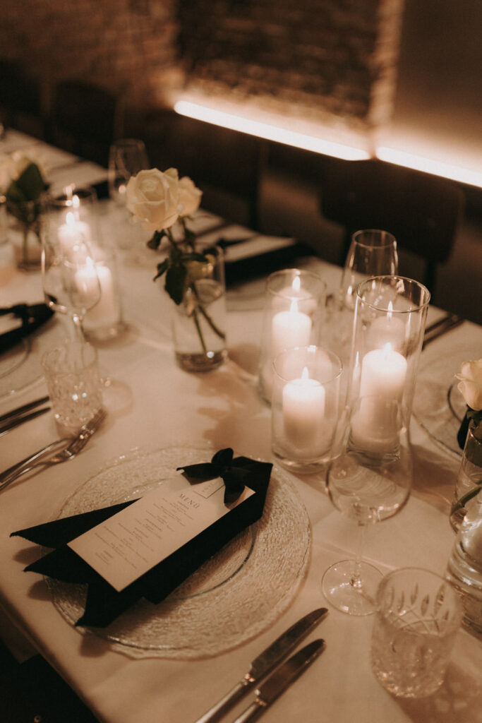 Elegant wedding dinner setup with candles and florals – reception detail